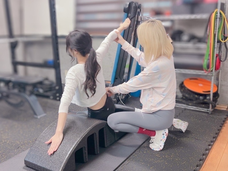 女性トレーナーが指導するピラティスの様子